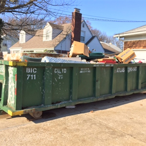 Dumpster in driveway with garbage